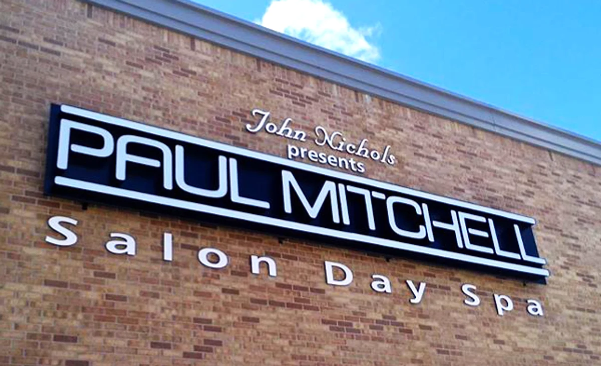 Illuminated channel letters reading “Paul Mitchell Salon Day Spa” mounted on a brick facade